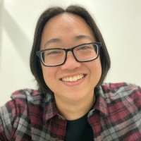 Close-up shot of Stephanie Lim, an Asian woman with short black hair and glasses, smiling into the camera.