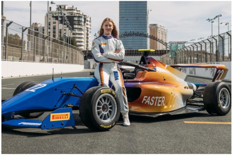 Image of woman in racing suit standing in front of a race car.