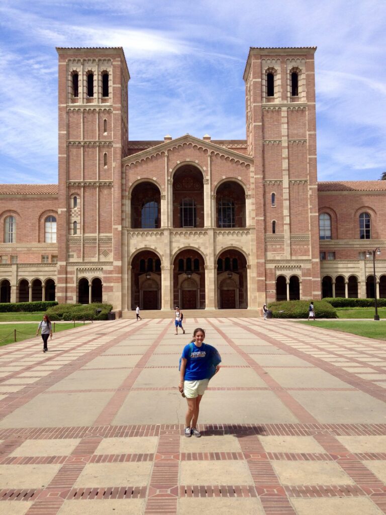Student poses in front of Royce Hall during the day.