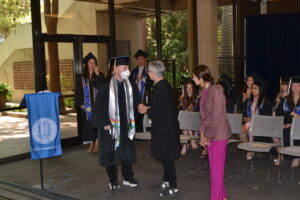 Scholarship winner Roxas Haze shakes hands with Chair Marks and Dean Galvan.